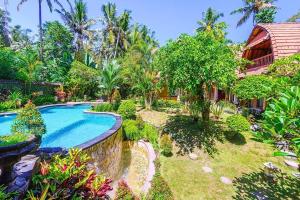 a garden with a swimming pool and a house at Jineng 5 BR Private Pool Villa with Stunning Garden by Basma Groups in Ubud