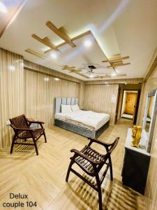 - une chambre avec un lit, deux chaises et une table dans l'établissement Hotel five star Skardu, à Skardu