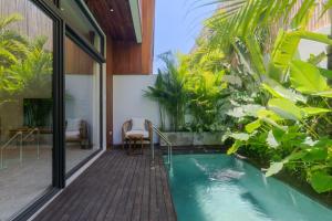 a swimming pool in a house with a garden at Sunny Cuddles in Canggu