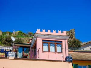 ein rosa Haus auf einem Gebäude in der Unterkunft La Torretta dei Merli with Views in Vernazza