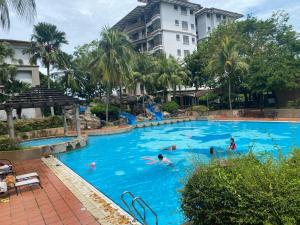 un grupo de personas nadando en una gran piscina en Malacca Five-O Seaview Apartment, en Melaka