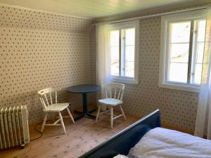 um quarto com duas cadeiras, uma mesa e uma cama em Guddals Tunet em Rosendal