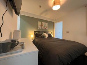 a bedroom with a black bed and a white counter at Myrtle Villas in Hull