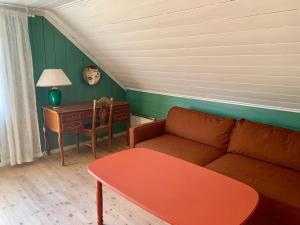 uma sala de estar com um sofá, uma mesa e uma secretária em Guddals Tunet em Rosendal
