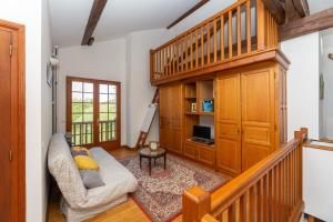 uma sala de estar com uma escada e um sofá em L'Errekaldea - Vue montagne et piscine privée em Masparraute