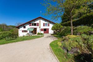 una casa con un camino de tierra delante de ella en L'Errekaldea - Vue montagne et piscine privée, en Masparraute
