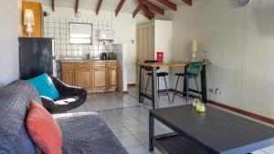 ein Wohnzimmer mit einem Sofa und einem Tisch sowie eine Küche in der Unterkunft Talk of the Town Inn & Suites - St Eustatius in Oranjestad