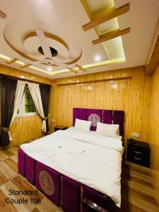 - une chambre avec un grand lit et une tête de lit violette dans l'établissement Hotel five star Skardu, à Skardu