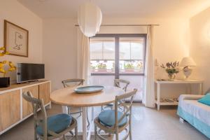 mały salon ze stołem i krzesłami w obiekcie Orosei Home Holidays - I fiori w mieście Orosei