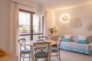 a living room with a table and chairs and a couch at Orosei Home Holidays - I fiori in Orosei