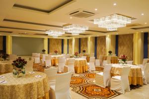 a banquet hall with tables and chairs and chandeliers at Country Inn Anant Ayodhya in Ayodhya