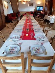 a long table with plates and glasses on it at Maison spacieuse avec piscine et vue sur jardin à Fourches in Fourches