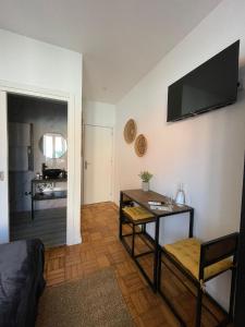 ein Wohnzimmer mit einem Tisch und einem TV an der Wand in der Unterkunft 100 Contos in Porto