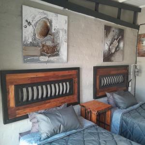 due letti in una stanza con due letti e quadri di At Ease Road Lodge a Zeerust