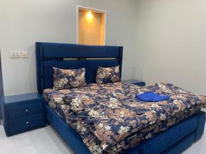 a blue bed with a blue headboard and pillows at Park View Residency 1 in Rawalpindi