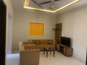 uma sala de estar com um sofá e uma televisão em Park View Residency 1 em Rawalpindi