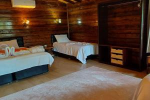 two beds in a room with wooden walls at Angels Garden Hotel in Olympos +105 photos