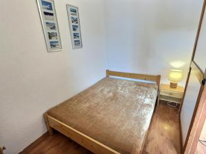 een kleine slaapkamer met een bed en een nachtkastje bij Appartement Val-d'Isère, 2 pièces, 4 personnes - FR-1-411-153 in Val dʼIsère