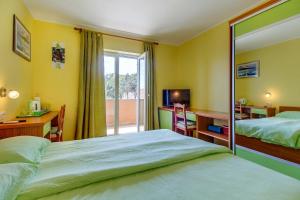 a bedroom with a bed and a desk and a window at House MARISSA by the sea with sea view in Nerezine
