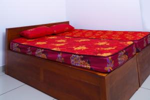 a wooden bed with red pillows on top of it at THEKKUMPURAM RESIDENCY in Kondotti