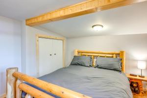 a bedroom with a bed with a wooden headboard at Cottage with Deck and Bluff Lake Views Walk to Beach! in Lake