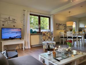 a living room with a couch and a tv on a table at Ferienwohnung Seelboomler in Sankt Peter-Ording
