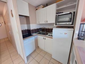 a small kitchen with a microwave and a refrigerator at Appartement Les Deux Alpes, 2 pièces, 6 personnes - FR-1-516-60 in Les Deux Alpes