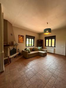 een woonkamer met een bank en een open haard bij Villa Sara on Etna in Pedara