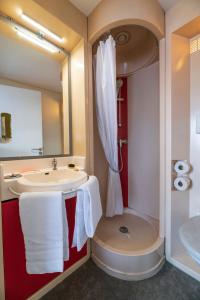 La salle de bains est pourvue d'un lavabo, d'une douche et de serviettes. dans l'établissement Cerise Nantes La Beaujoire, à Nantes