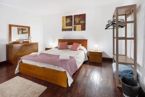 a bedroom with a large bed and a ladder at Casa Dona Isaura in Ponta Delgada