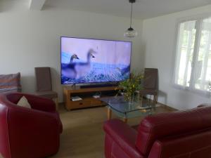 uma sala de estar com uma grande televisão de ecrã plano em Maison à Saint-Augustin/mer proche de Saint Palais em Saint-Augustin