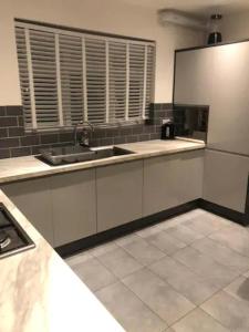 - une cuisine avec un évier et un comptoir dans l'établissement Charming 3-Bed Apartment in London, à Hendon
