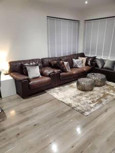 - un canapé en cuir brun dans le salon dans l'établissement Charming 3-Bed Apartment in London, à Hendon