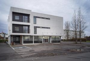 un parcheggio vuoto di fronte a un edificio di Hotel Lotus a Reykjavik