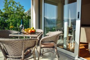 Una mesa con un bol de fruta en un balcón. en Sea view apartment for 4, en Kotor