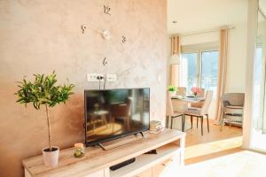 Una sala de estar con un televisor de pantalla plana sobre una mesa. en Sea view apartment for 4, en Kotor