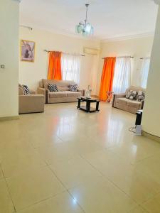 uma grande sala de estar com dois sofás e uma mesa em Miraph Apartment em Abuja
