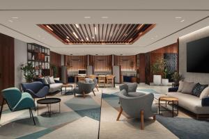 カサブランカにあるCourtyard by Marriott Casablanca Downtownの椅子とテレビのあるロビーの2枚の画像