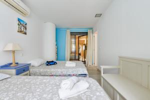 Un dormitorio con dos camas y una pared azul. en Enorme apartamiento en CALA ALTA de Villajoyosa, en Cala de Finestrat 32 fotos más