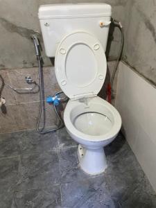 a white toilet in a bathroom with a shower at Area51 Glamps in Manāli