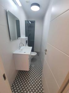 La salle de bains blanche est pourvue d'un lavabo et d'un miroir. dans l'établissement Bograshov Modern 2BR Apartment, à Tel Aviv