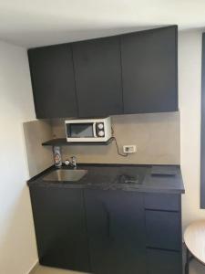 La cuisine est équipée d'un évier et d'un four micro-ondes. dans l'établissement Bograshov Modern 2BR Apartment, à Tel Aviv