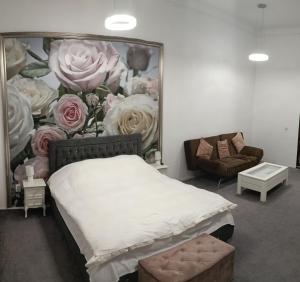 een slaapkamer met een bed en een schilderij van rozen bij Samuel House in Sibiu