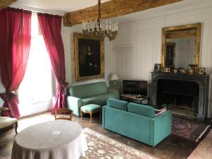 a living room with a green couch and a fireplace at Chambres d'hôtes Château de Bonabry in Hillion