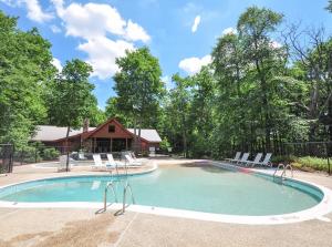 a swimming pool with chairs and a house at Dreidels Den in McHenry