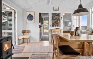 Awesome Home In Hirtshals With Kitchen في هيرتسهلس: مطبخ وغرفة معيشة مع موقد وطاولة