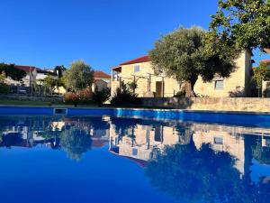 a pool of blue water in front of a house at Casa da Maravilhas in Viana do Castelo