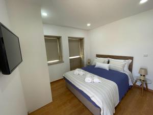 a bedroom with a bed and a flat screen tv at Casa da Maravilhas in Viana do Castelo +22 photos