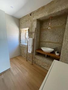 a bathroom with a stone wall with a sink at Casa da Maravilhas in Viana do Castelo