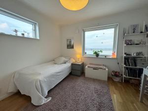 um quarto com uma cama e duas janelas em Fantastic villa with a sea view in Torslanda em Torslanda